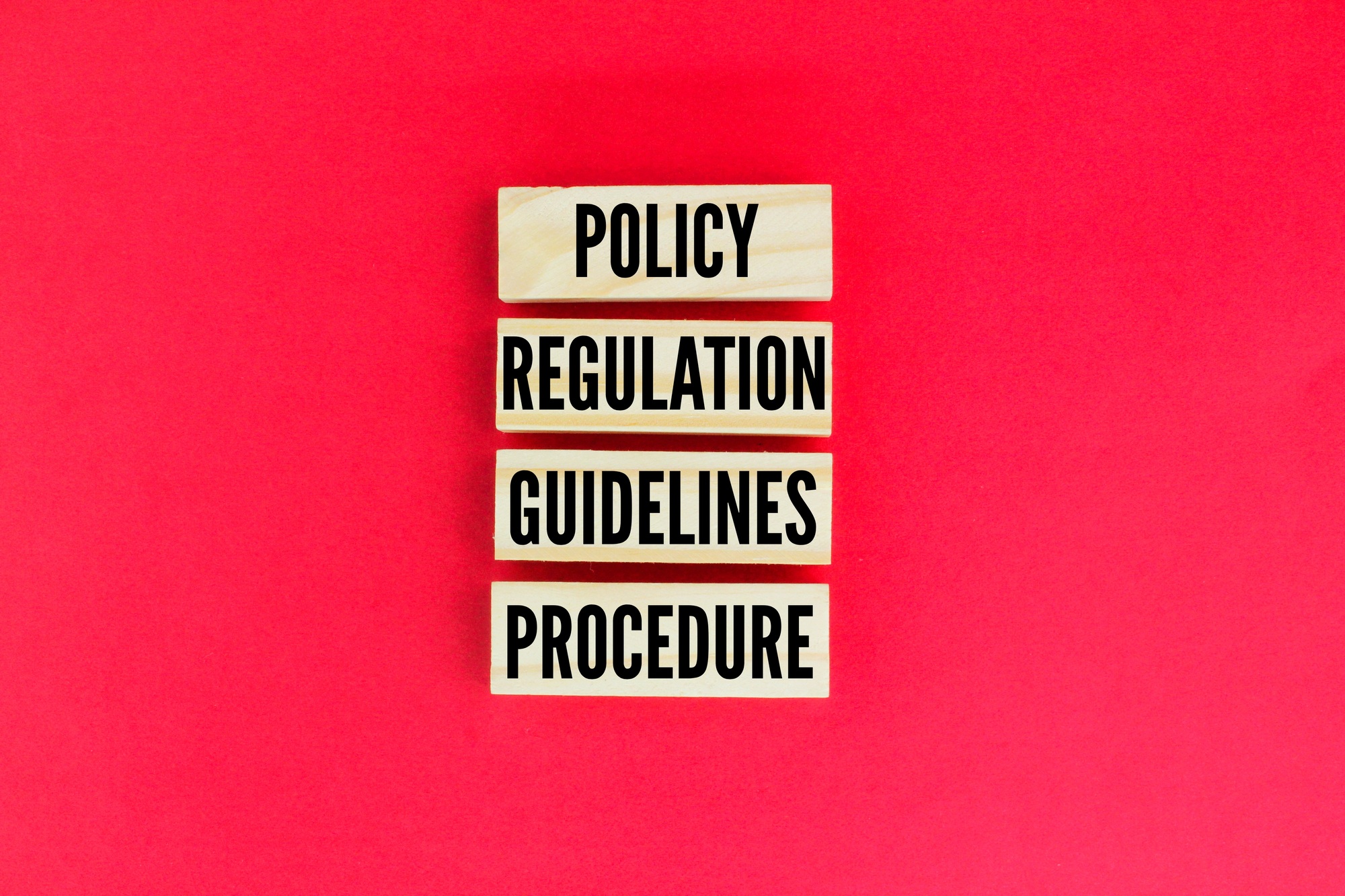 wooden arrangement with the words Policy Regulation Guidelines Procedure.