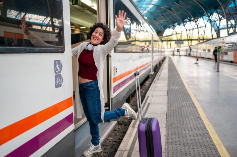 Happy tourist waving goodbye while leaving train at station